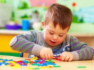 Child assembles crafts at table